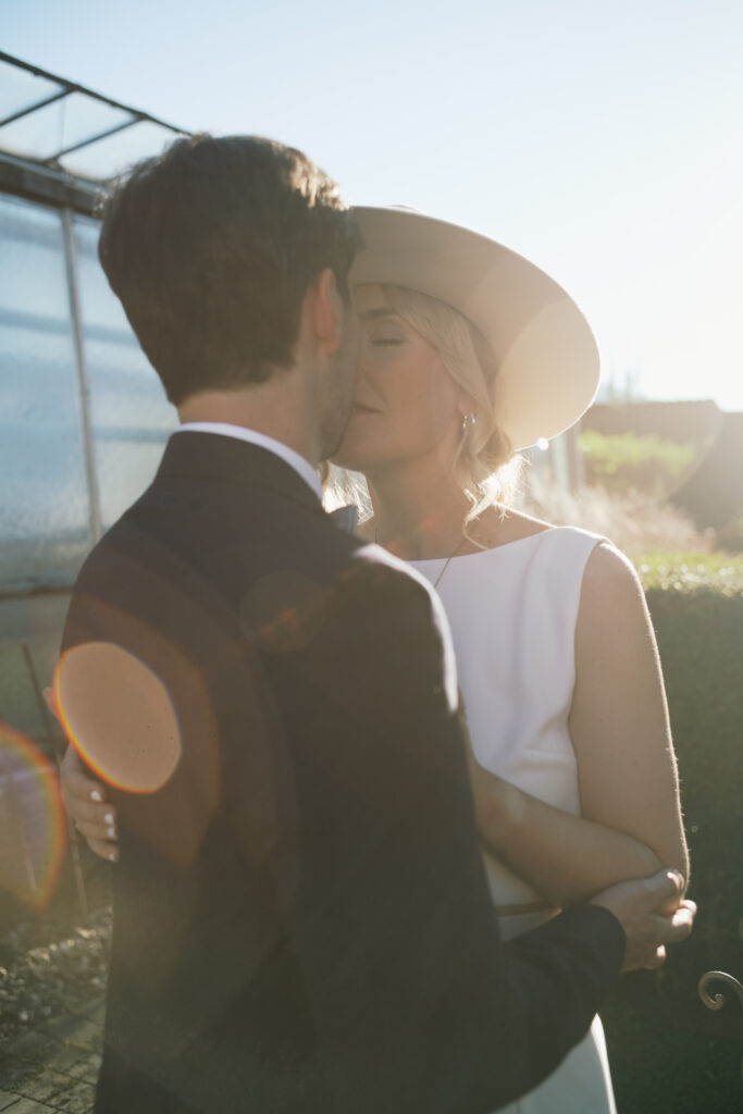 Brautpaar küsst sich im Gegenlicht – Hochzeitsfotografie Steiermark
