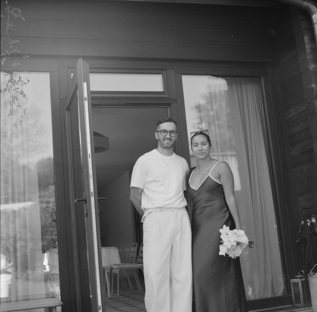 Brautpaar im Türrahmen – analoge Hochzeitsfotografie